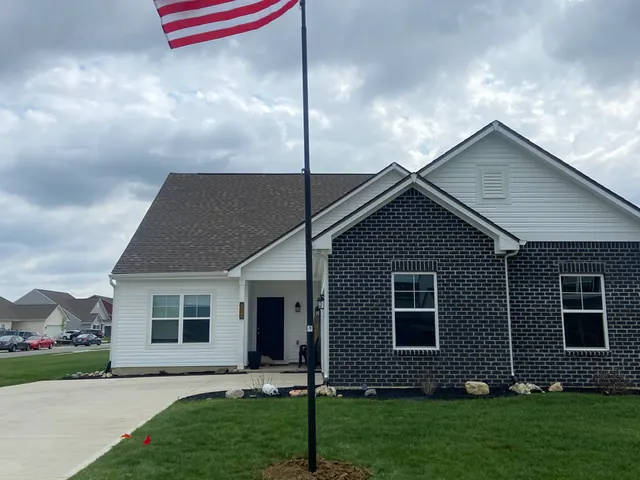Newly built home in central Indiana with a residential flagpole set in the front lawn