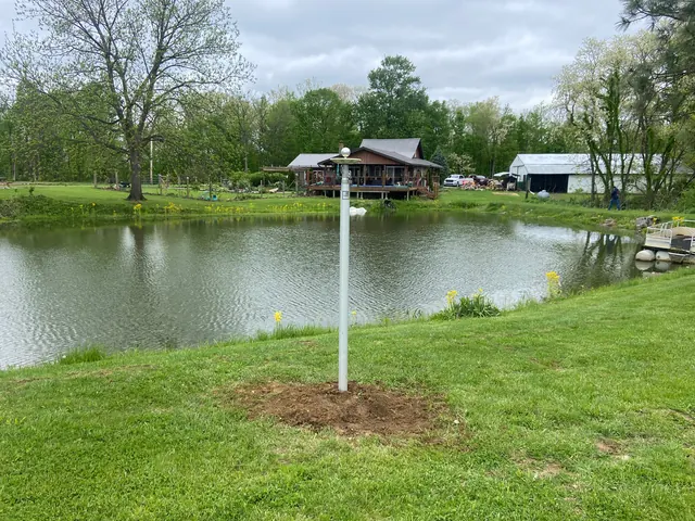 Residential pole set on a property overlooking a pond.