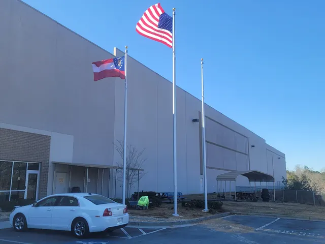 Multiple commercial flagpoles outside a large distribution facility in central Indiana